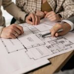 Professional team reviewing architectural floor plans for custom home design