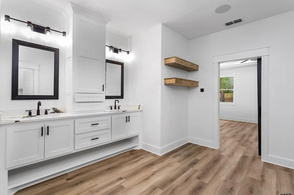 Custom bathroom with double vanity, black-framed mirrors and floating wood shelves, designed by Prince Designs in Tyler, Texas